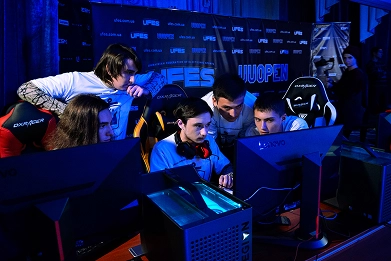 E-sportspelers die samen geconcentreerd achter computers zitten tijdens een competitief toernooi.